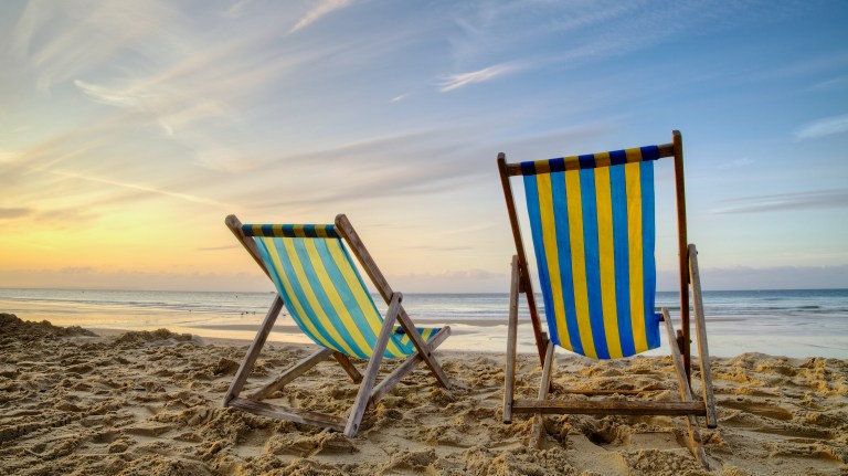 Two empty deck chairs on the beach